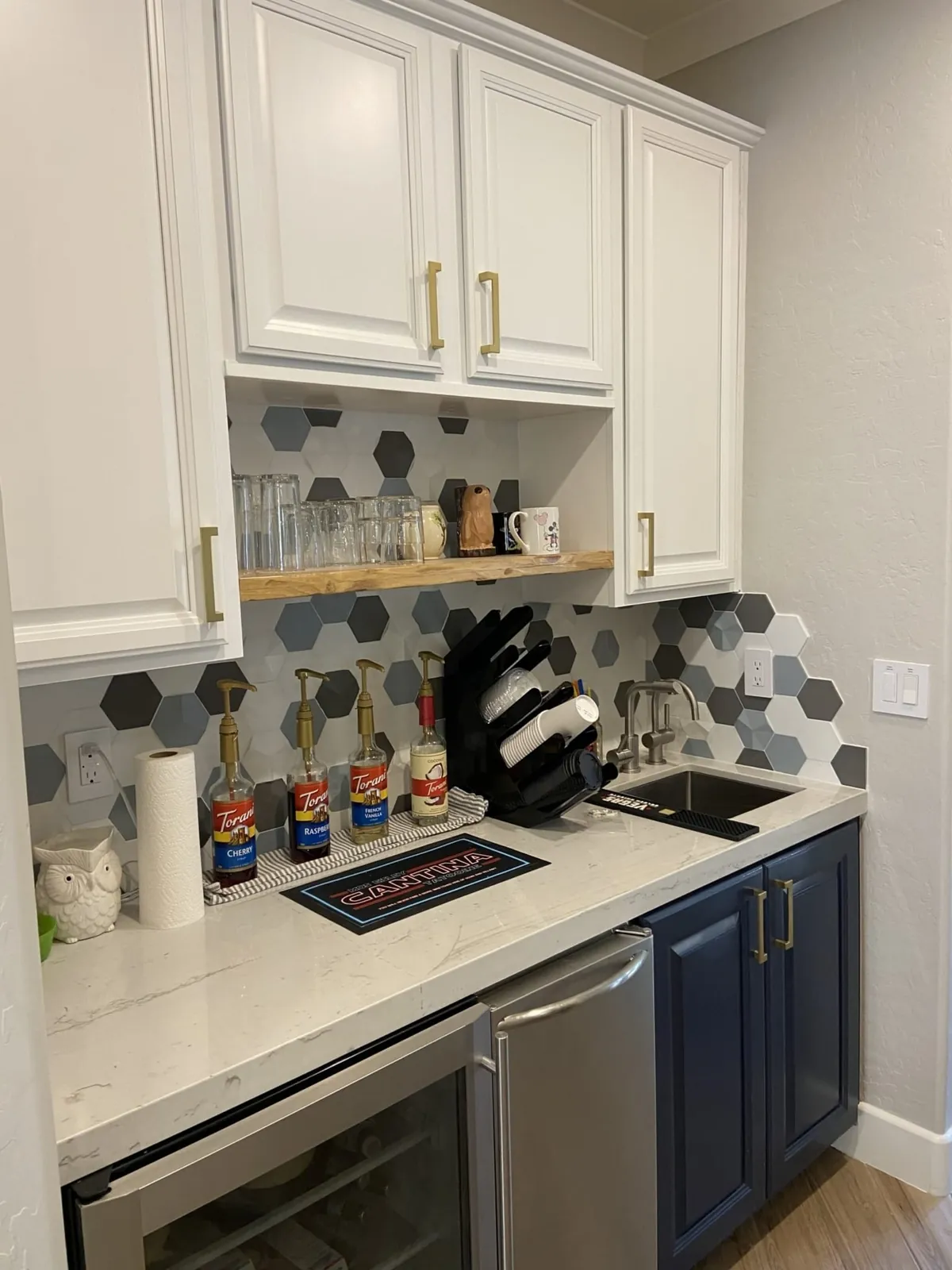 The butler's pantry with open shelves and a hex tile backsplash