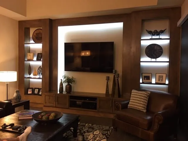 Wood entertainment center lit at night with glowing display niches