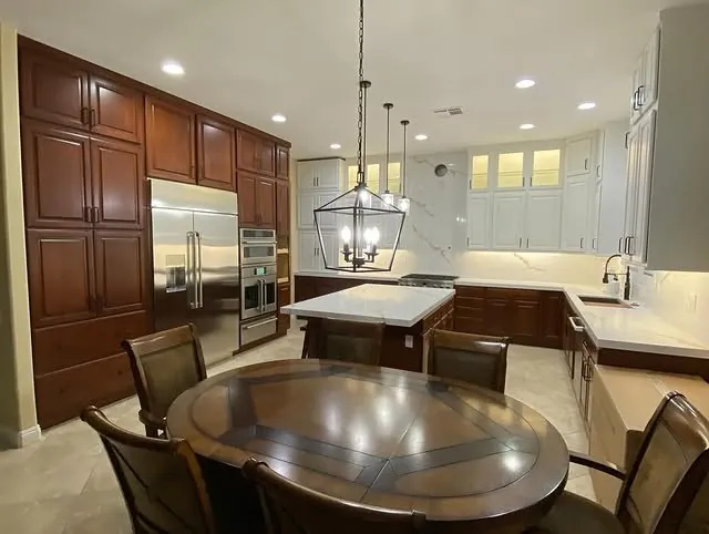 Breakfast area and cherry pantry wall with pendant lights over the island