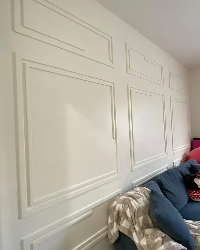 Playroom wall finished with white picture-frame panelling