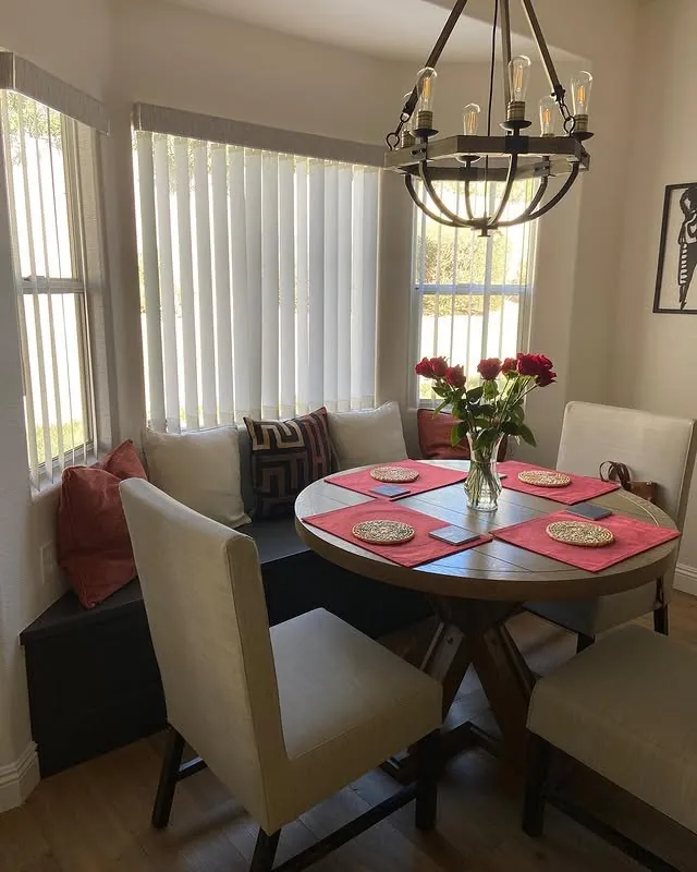 Breakfast nook with a round table beside tall windows