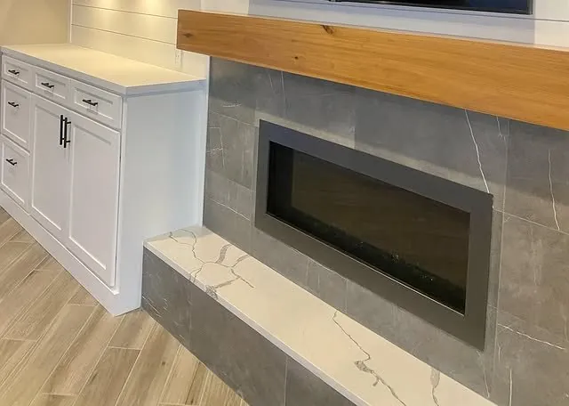 Linear fireplace with a stone-look surround and a marble hearth