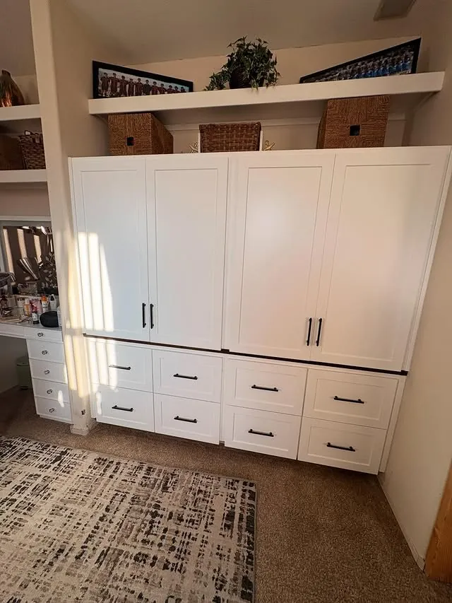 White closet cabinetry with tall doors over a bank of drawers