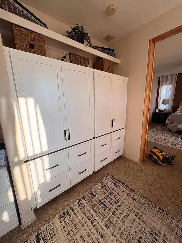 Side view of the white closet cabinets reaching the ceiling