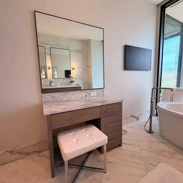 The makeup vanity beside a freestanding tub and a window onto the mountains