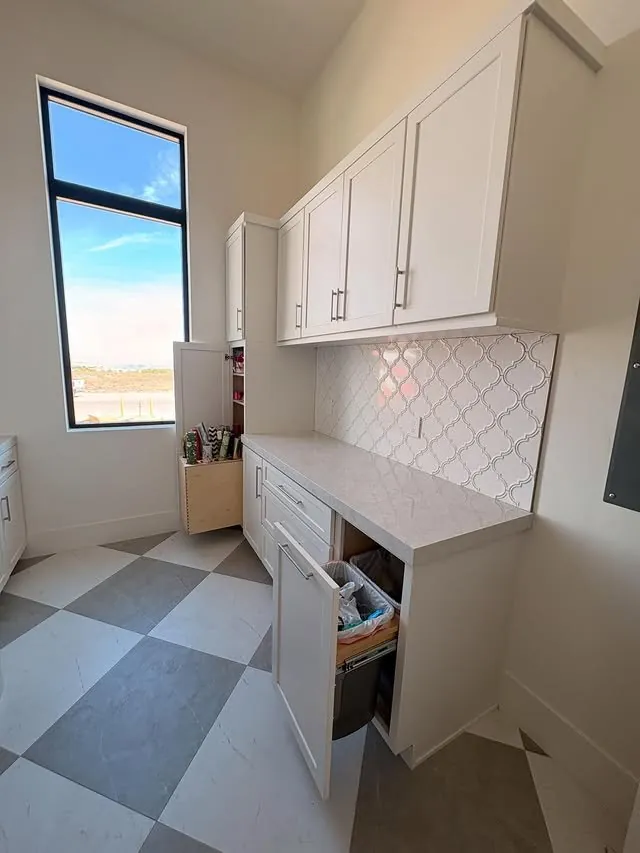 White laundry cabinets with a pull-out drawer opened