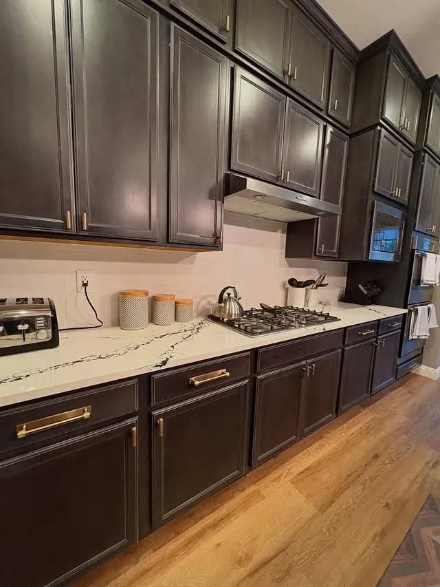 Dark wall cabinets over a white quartz counter and range