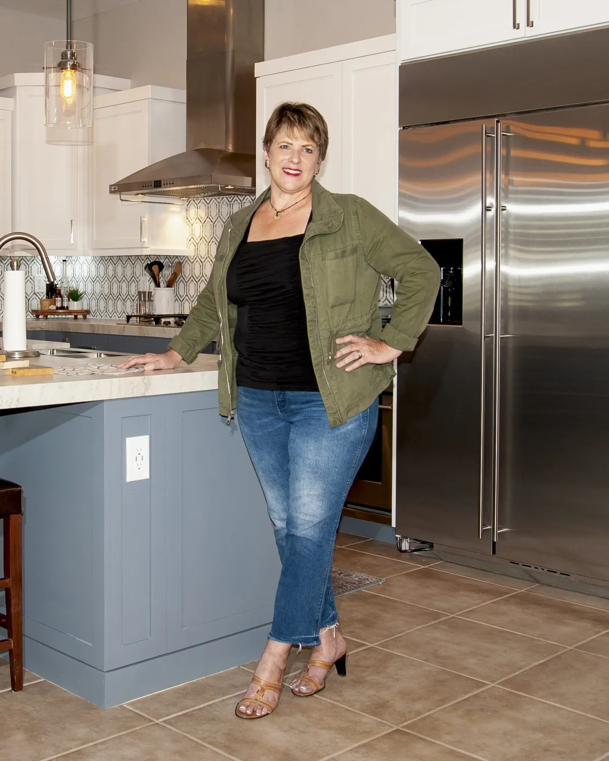 Judy Burrell, designer and owner of JB Custom Design, standing at a kitchen island