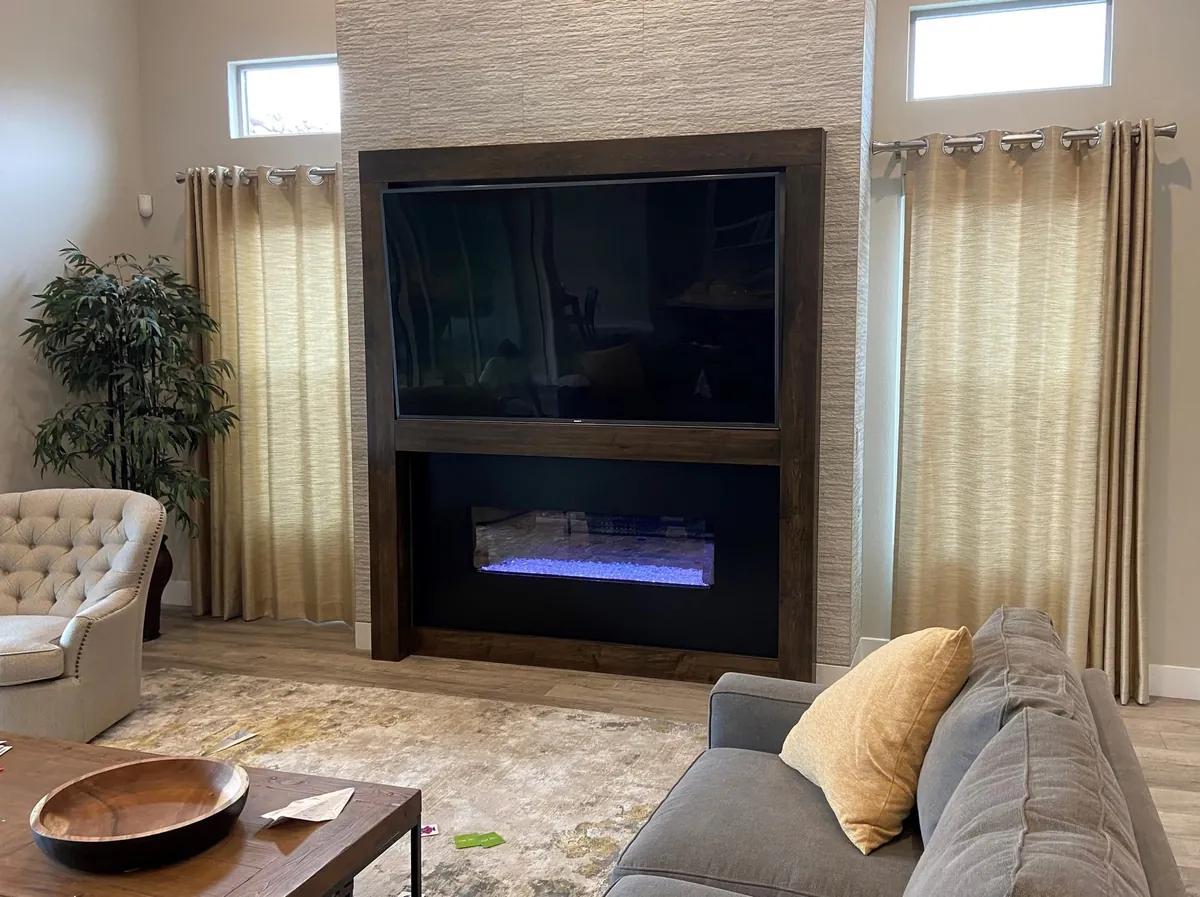 The stone media wall from the sofa, with the fireplace lit