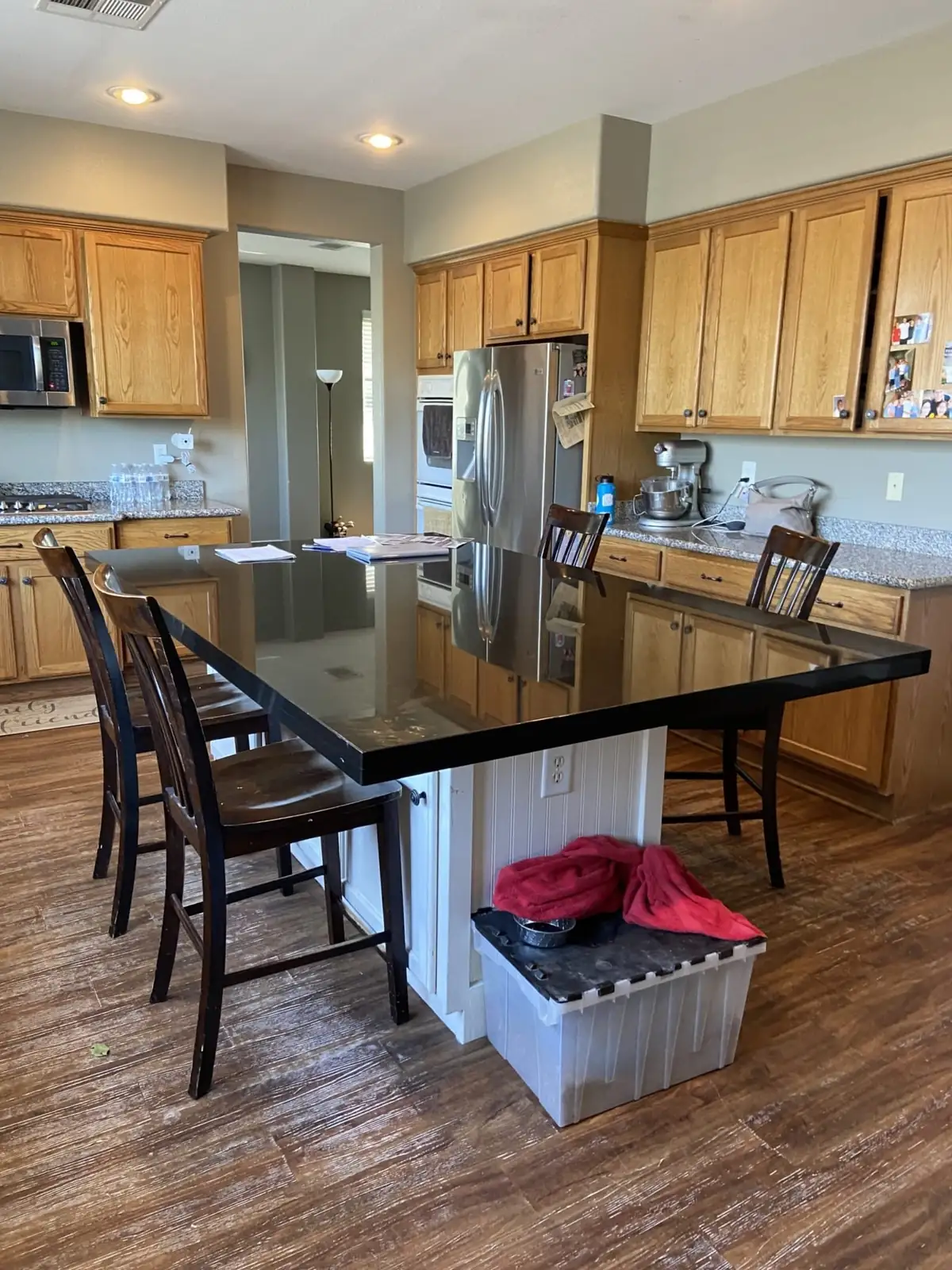 The same kitchen before: honey oak cabinets and a black-topped island